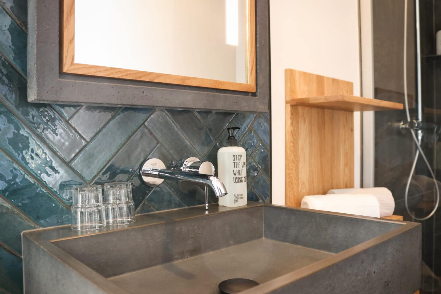 Mountainbike- & Outdoor-Sport-Unterkunft Harz-BnB Werkmeister - Detail im Superior-Badezimmer in der Bergwerksetage, schwarzer Betonspiegel und Betonwaschbecken, Eichenregal