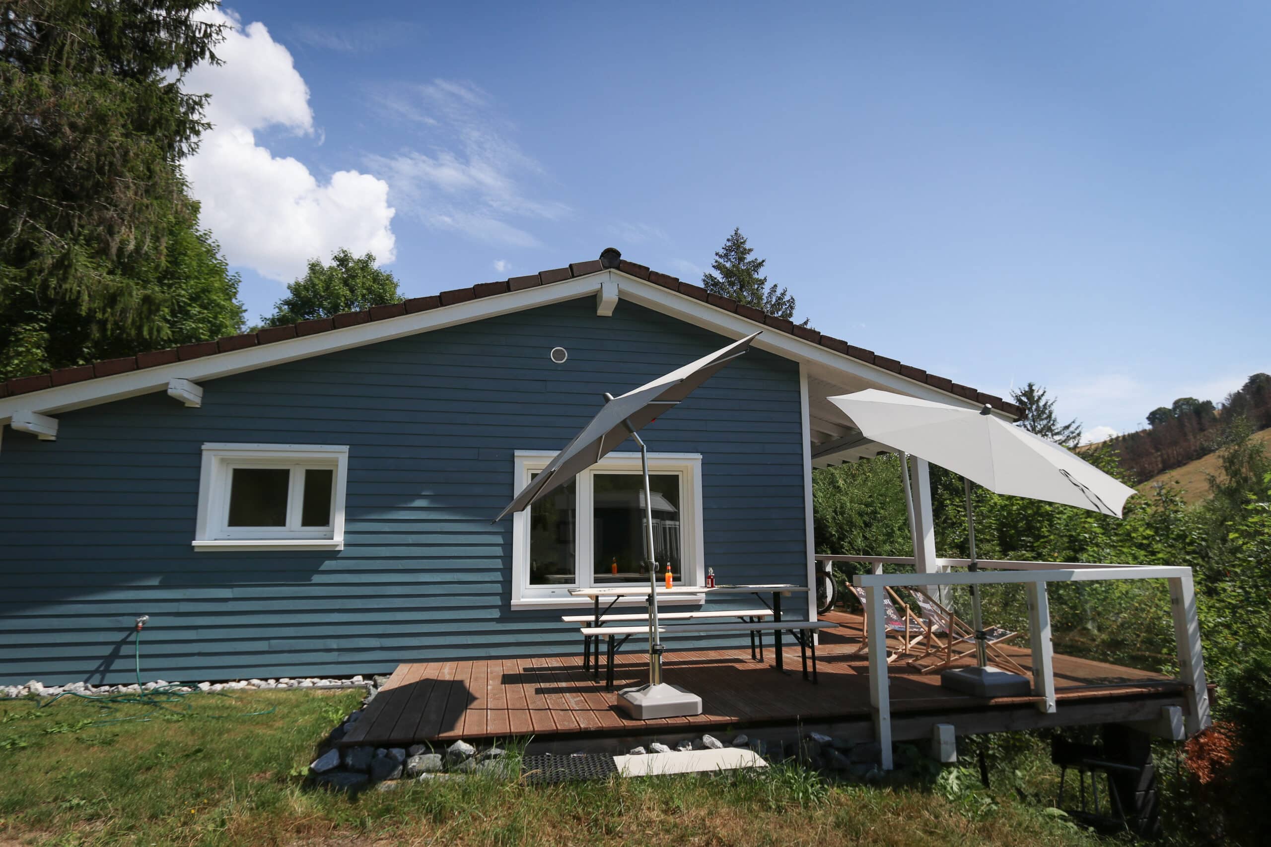 Mountainbike- & Outdoor-Sport-Unterkunft Harz-BnB Werkmeister - Werkmeisters Hütte, Außenansicht, Terrasse mit Sonnenschirmen, Ausblick auf den Matthias-Schmidt-Berg, sommerlich